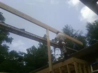 Carpenter setting a ridge beam over a new addition frame — Ice Dam Removal by Roofing Brothers in Swaledale