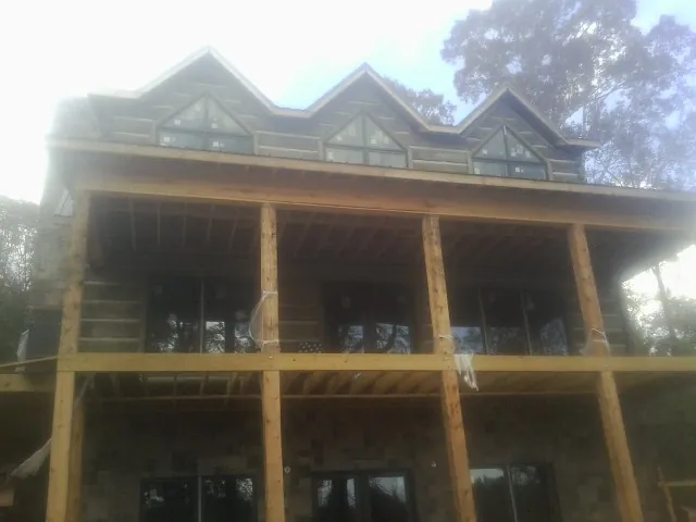 Dormers and porch framing on a large log home under construction — Roof Coating work by our crew in Swaledale